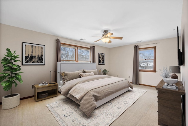 bedroom featuring visible vents, baseboards, light carpet, and multiple windows