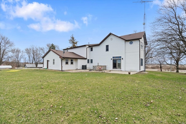 back of house featuring a lawn, cooling unit, and a patio area