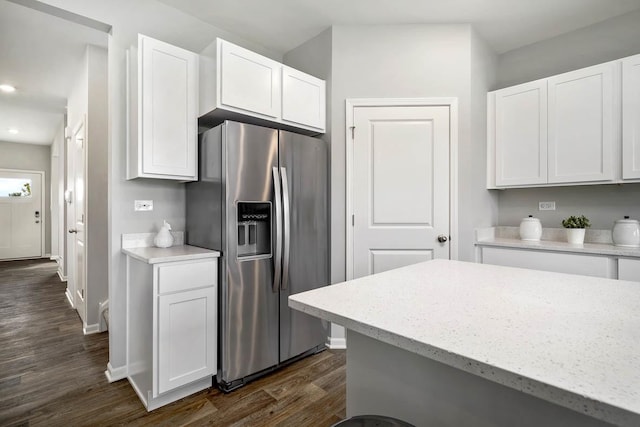 kitchen featuring stainless steel fridge, baseboards, dark wood-style flooring, and white cabinetry