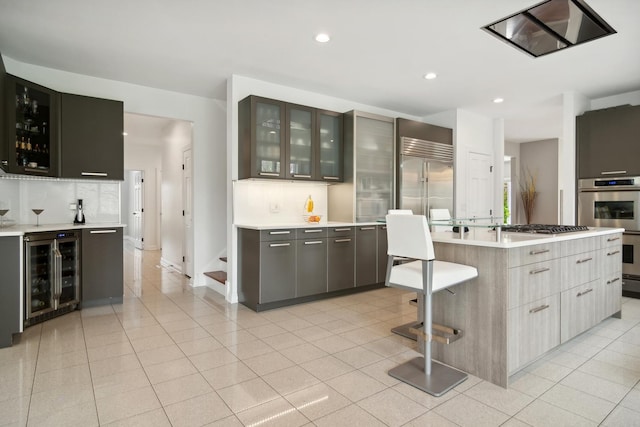 12 Forest Ln, South Barrington, IL 60010 - kitchen with light countertops, beverage cooler, recessed lighting, tasteful backsplash, and glass insert cabinets