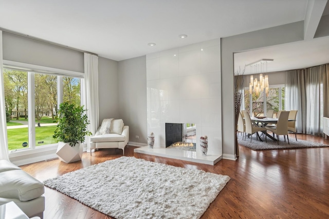 12 Forest Ln, South Barrington, IL 60010 - living room featuring a chandelier, a tiled fireplace, a healthy amount of sunlight, and wood finished floors