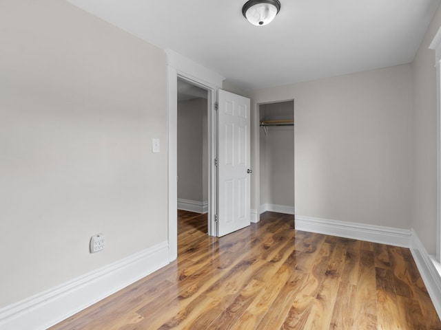 908 Superior St, Aurora, IL 60505 - unfurnished bedroom with baseboards, a closet, and wood finished floors