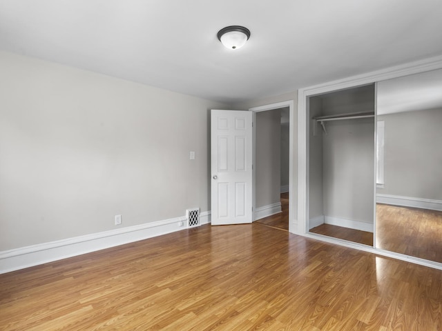 908 Superior St, Aurora, IL 60505 - unfurnished bedroom featuring a closet, wood finished floors, and baseboards