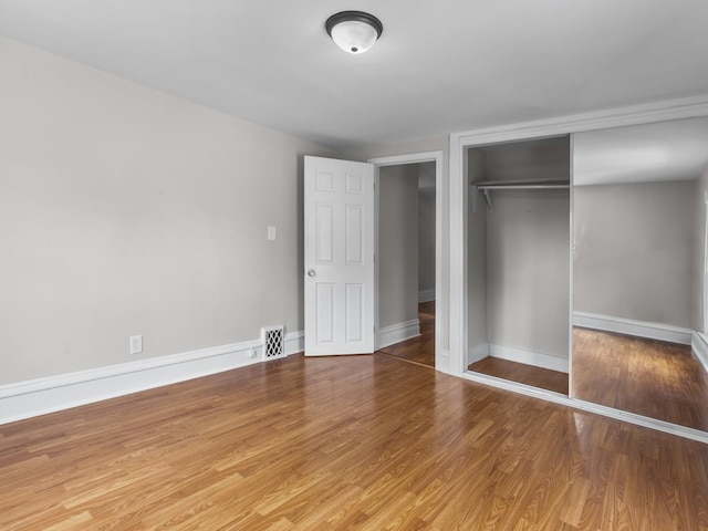 908 Superior St, Aurora, IL 60505 - unfurnished bedroom with light wood-type flooring, a closet, and baseboards