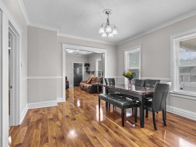 908 Superior St, Aurora, IL 60505 - dining space featuring a chandelier, wood finished floors, a textured ceiling, ornamental molding, and baseboards