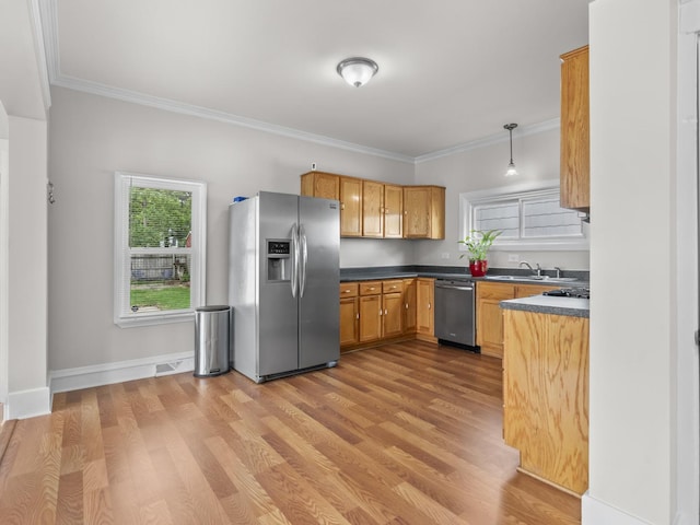 908 Superior St, Aurora, IL 60505 - kitchen featuring stainless steel appliances, ornamental molding, dark countertops, a sink, and light wood-style flooring