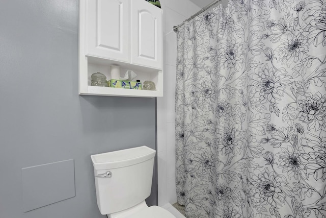 bathroom with toilet and a shower with curtain