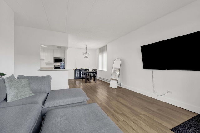 living area with baseboards and wood finished floors
