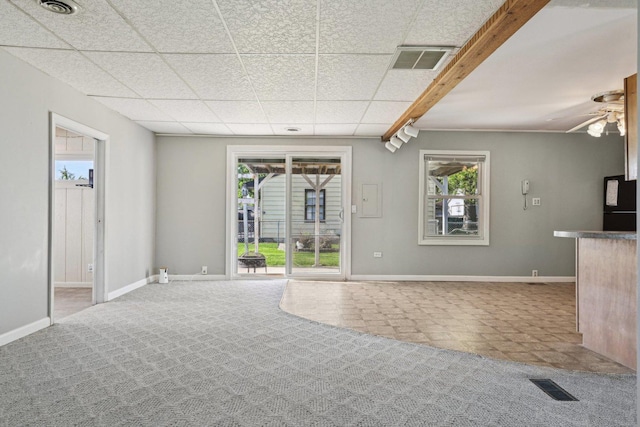 27 Arlington Dr, Romeoville, IL 60446 - unfurnished living room featuring baseboards, plenty of natural light, a ceiling fan, and a paneled ceiling