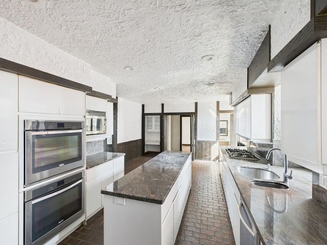 5555 S Everett Ave Unit B3-4, Chicago, IL 60637 - kitchen with a sink, stainless steel appliances, brick floor, a textured ceiling, and white cabinets