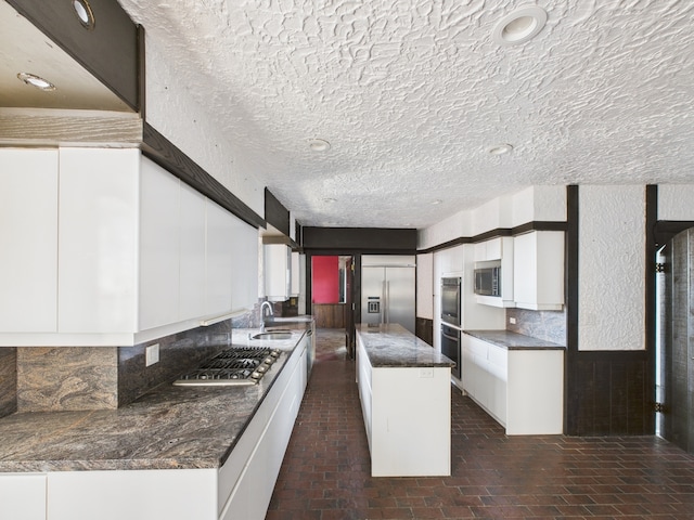 5555 S Everett Ave Unit B3-4, Chicago, IL 60637 - kitchen featuring a sink, stainless steel appliances, white cabinetry, backsplash, and a center island