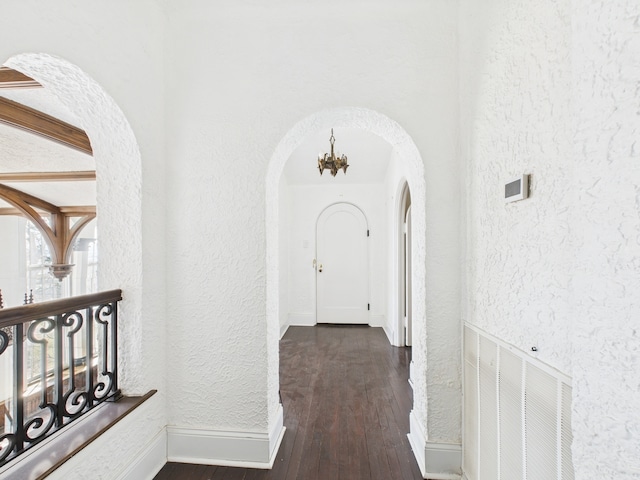 5555 S Everett Ave Unit B3-4, Chicago, IL 60637 - hall with dark wood finished floors, a textured wall, arched walkways, a notable chandelier, and baseboards