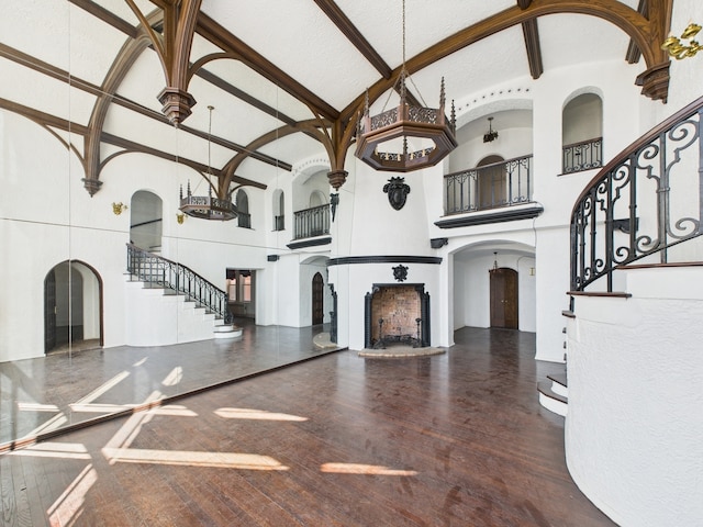 5555 S Everett Ave Unit B3-4, Chicago, IL 60637 - unfurnished living room with wood finished floors, high vaulted ceiling, a fireplace, arched walkways, and stairs