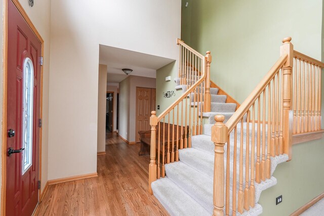 1678 Eagles Lndg N, Manteno, IL 60950 - entryway featuring wood finished floors, a high ceiling, stairway, and baseboards