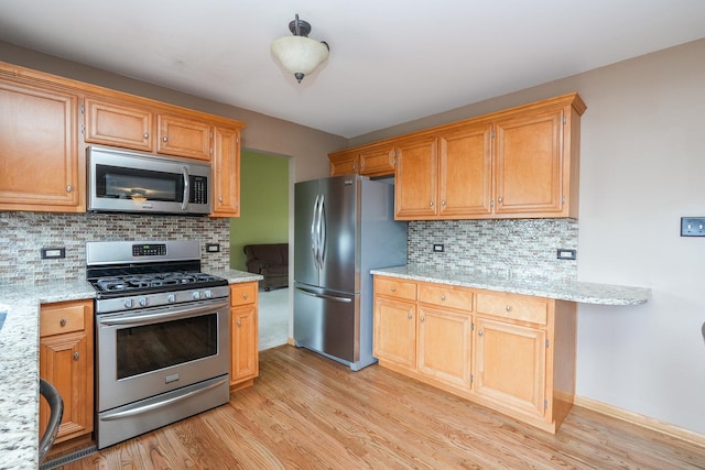 1678 Eagles Lndg N, Manteno, IL 60950 - kitchen featuring stainless steel appliances, light wood-style flooring, tasteful backsplash, and light stone counters