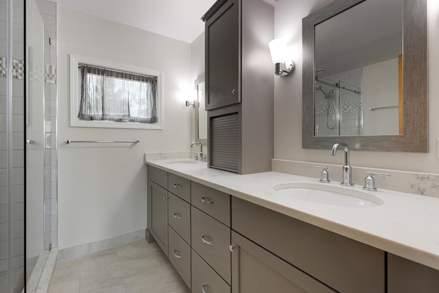bathroom with double vanity, baseboards, a tile shower, and a sink