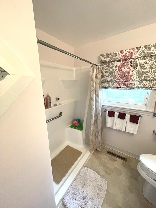 full bathroom featuring a stall shower, toilet, and visible vents