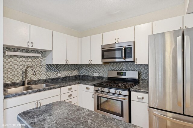 230 E Ontario St Unit 1205, Chicago, IL 60611 - kitchen with appliances with stainless steel finishes, a sink, white cabinets, and backsplash