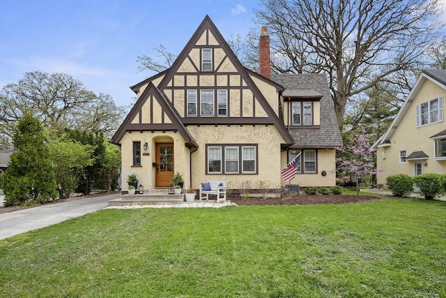 5619 Dunham Rd, Downers Grove, IL 60516 - english style home with stucco siding, roof with shingles, a front yard, and a chimney