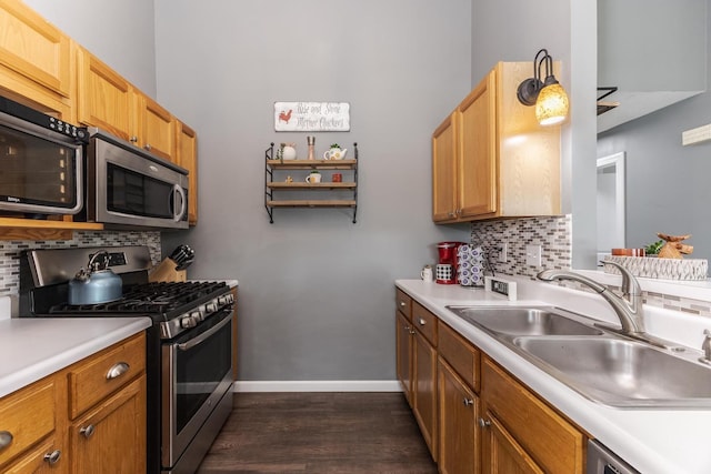 kitchen featuring tasteful backsplash, a sink, light countertops, stainless steel appliances, and dark wood-type flooring