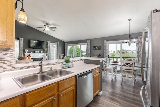 kitchen with lofted ceiling, a sink, ceiling fan with notable chandelier, open floor plan, and stainless steel appliances
