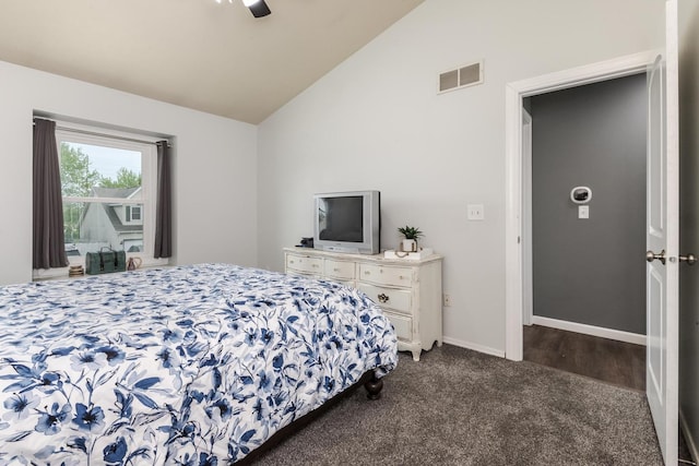 bedroom featuring visible vents, dark colored carpet, a ceiling fan, baseboards, and vaulted ceiling