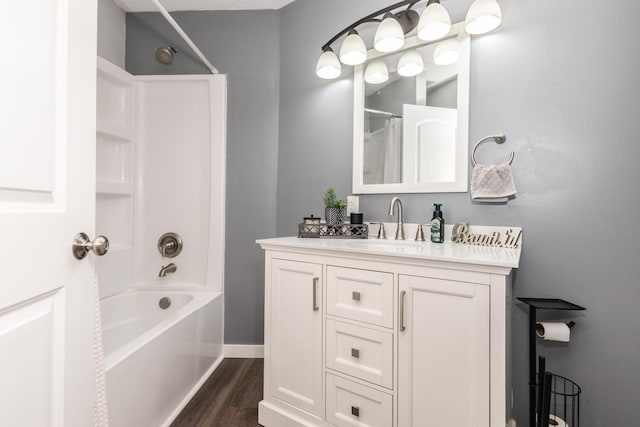 bathroom with baseboards, wood finished floors, shower / bath combo, and vanity