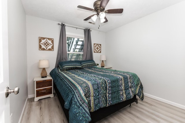 bedroom with baseboards, ceiling fan, wood finished floors, and visible vents