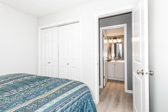 bedroom featuring light wood-style floors, a closet, and a sink