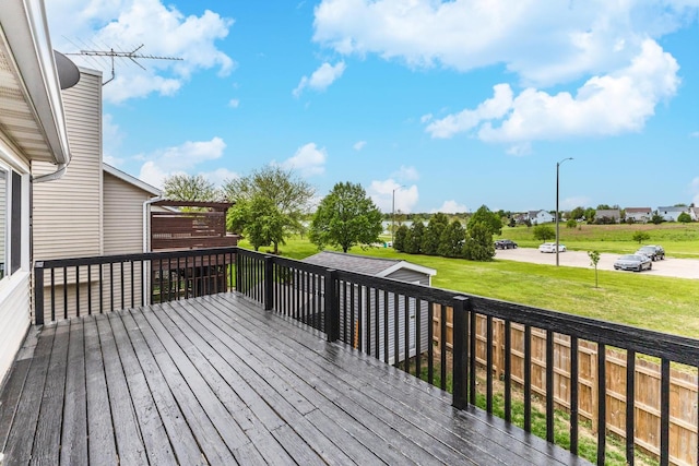wooden terrace with a lawn and an outbuilding