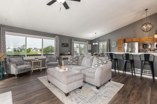 living area featuring vaulted ceiling, dark wood-style floors, and ceiling fan with notable chandelier