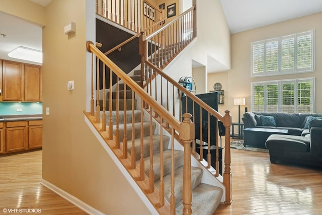 5515 Mcdonough Rd Unit 5515, Hoffman Estates, IL 60192 - staircase with a towering ceiling, hardwood / wood-style flooring, and baseboards