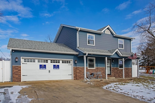 103 W Fourth S St, Chebanse, IL 60922 - craftsman-style home with a garage, fence, covered porch, brick siding, and concrete driveway