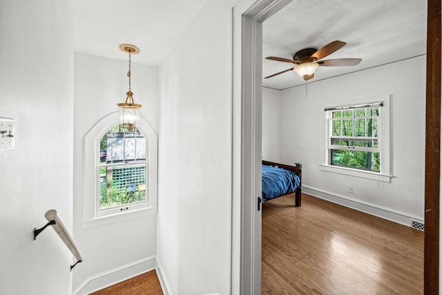 interior space featuring baseboards, wood finished floors, and an upstairs landing