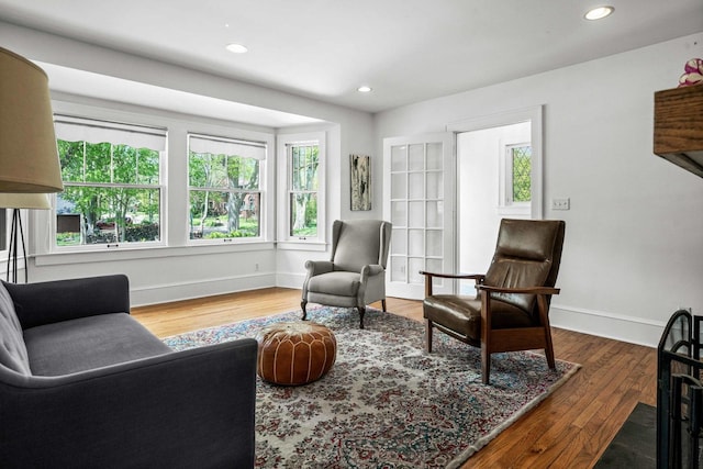living area featuring baseboards, recessed lighting, and wood finished floors