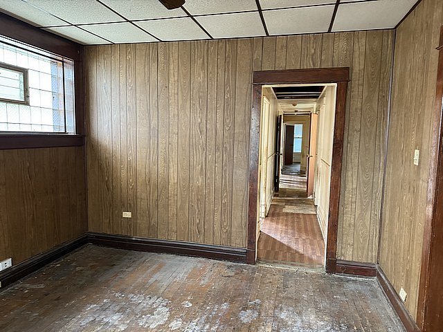 spare room featuring wooden walls and hardwood / wood-style flooring