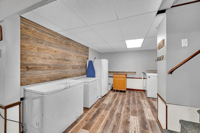 laundry area with light wood-type flooring, cabinet space, and washer and dryer
