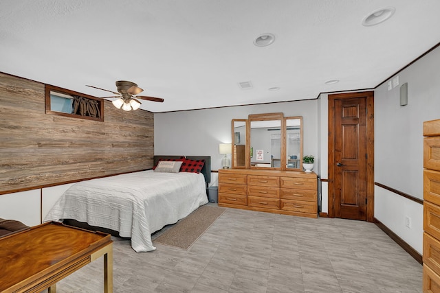 bedroom featuring recessed lighting, wood walls, light floors, and a ceiling fan