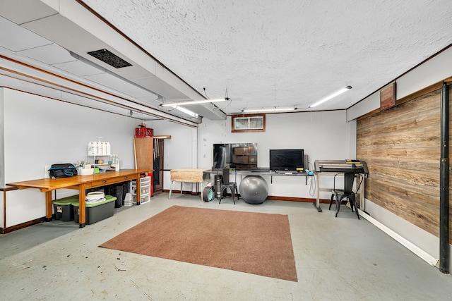 interior space featuring a textured ceiling, baseboards, and concrete floors