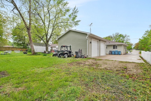 exterior space with fence, a yard, and a garage