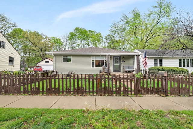 view of front of home featuring a porch, a fenced front yard, and a front lawn