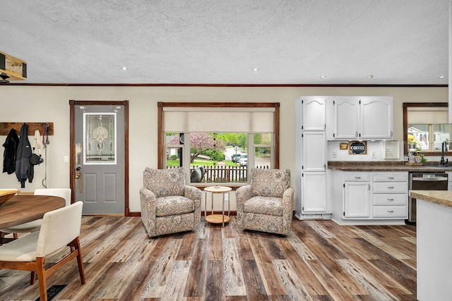 living area featuring crown molding, recessed lighting, a textured ceiling, and dark wood finished floors