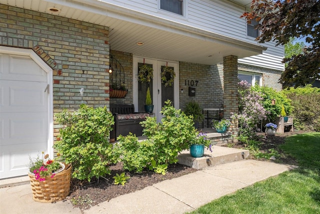 1107 N Bailey Dr, Pontiac, IL 61764 - property entrance featuring covered porch, brick siding, and a garage