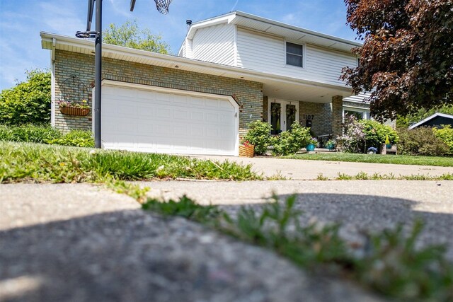 1107 N Bailey Dr, Pontiac, IL 61764 - view of front facade featuring brick siding, a garage, and concrete driveway