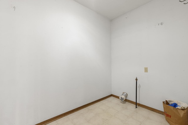laundry room with baseboards and light floors
