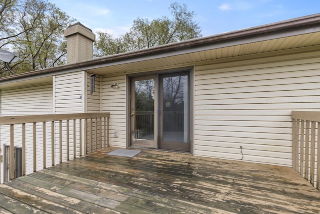 property entrance with a deck and a chimney