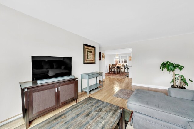 kitchen featuring wall chimney range hood, recessed lighting, light countertops, white cabinets, and gas stove