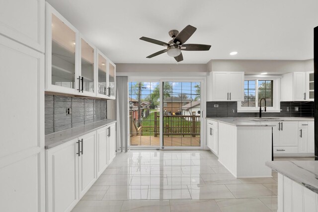 4424 Maple Ave, Brookfield, IL 60513 - kitchen featuring a sink, white cabinetry, a ceiling fan, and backsplash