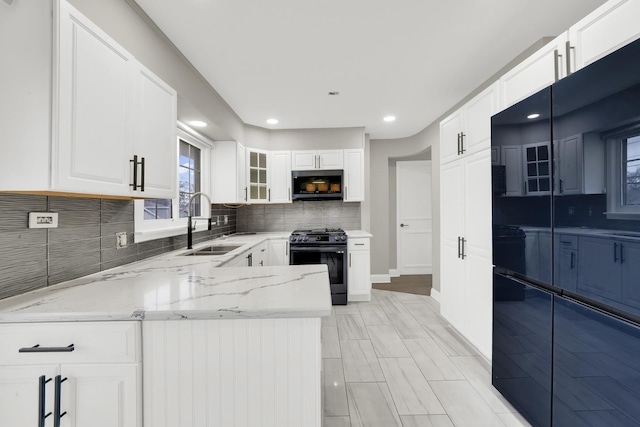 4424 Maple Ave, Brookfield, IL 60513 - kitchen featuring decorative backsplash, black range with gas cooktop, light stone countertops, a sink, and white cabinetry