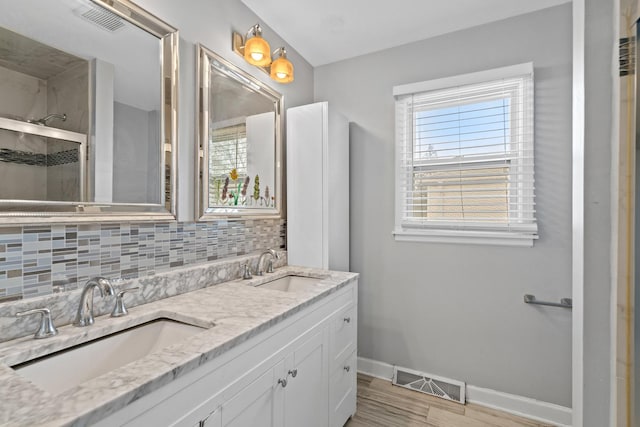 full bathroom featuring visible vents, a sink, baseboards, and a shower stall